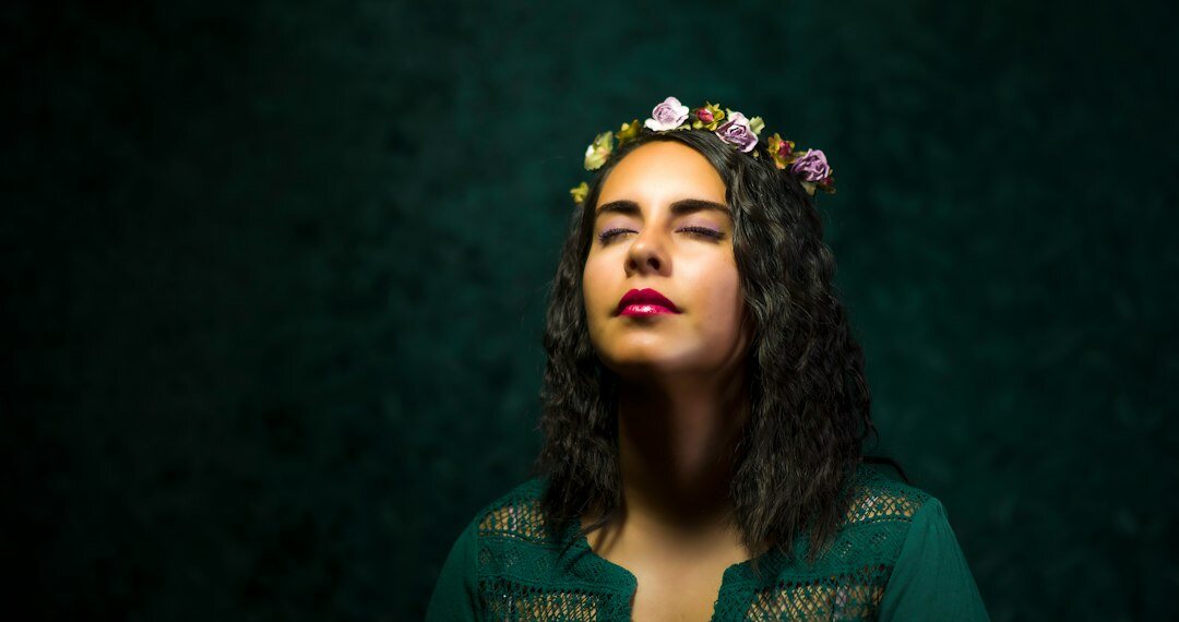 Studio portrait of a Mexican woman in her 30s with curly hair