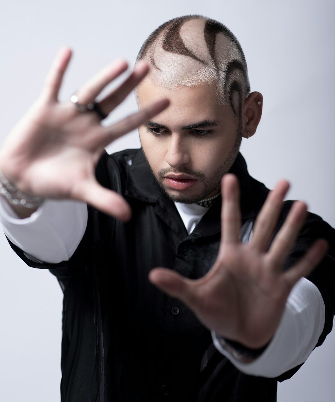 Studio portrait of a young Mexican man in a light suit
